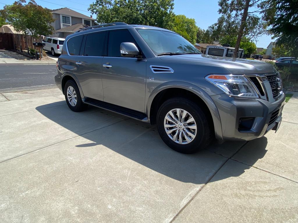 Gray Nissan Armada with tinted windows on a residential driveway