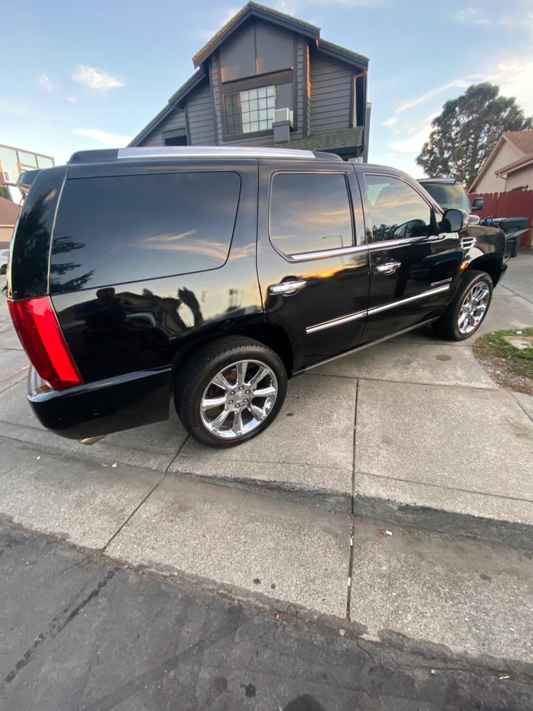 Black Cadillac Escalade with dark tinted windows parked on a driveway