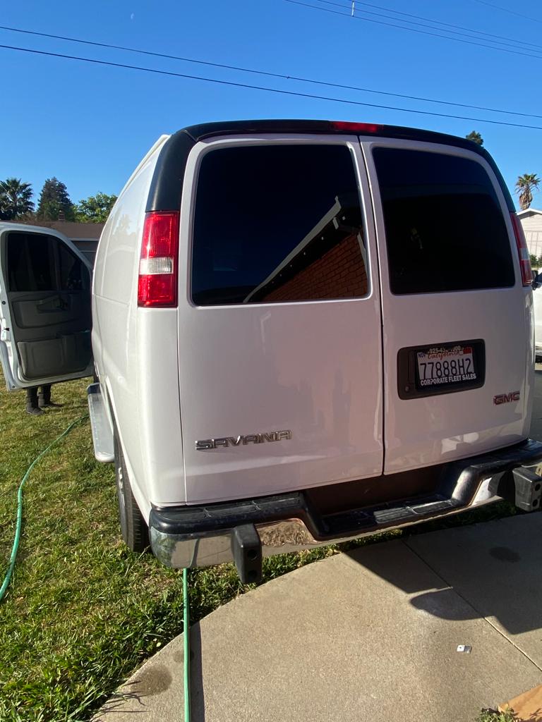 White GMC Savana cargo van with tinted rear door glass