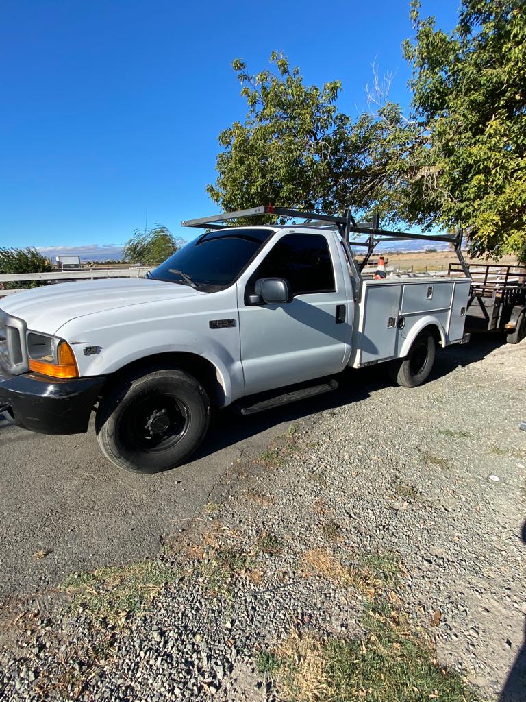White Ford utility bed work truck with tinted cab windows